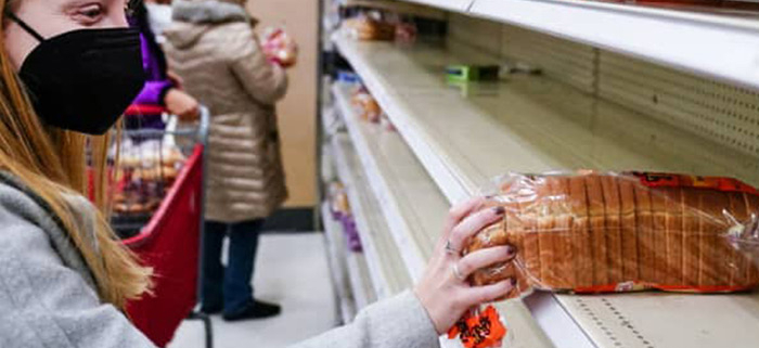 a buyer holding a loaf of bread