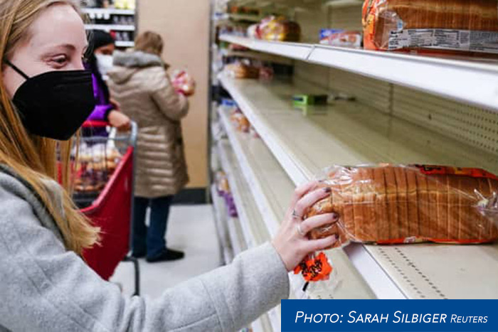 a buyer holding a loaf of bread